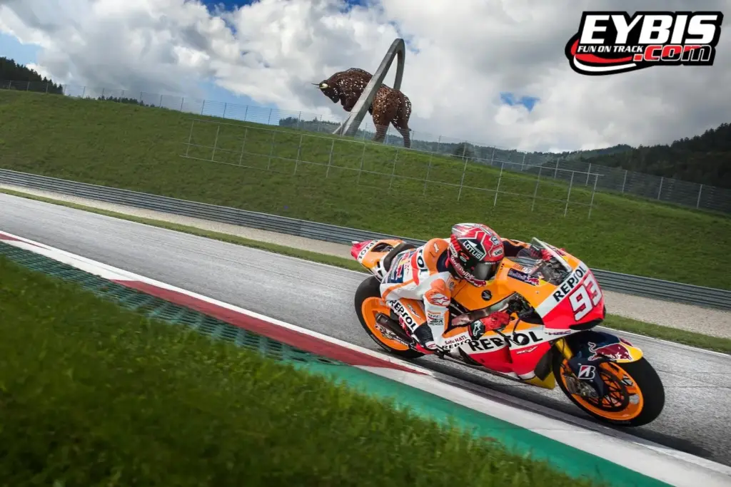 La moto Repsol affronta una curva veloce al Red Bull Ring durante l'evento Eybis del 6/7 luglio 2019, con il logo Eybis in alto.